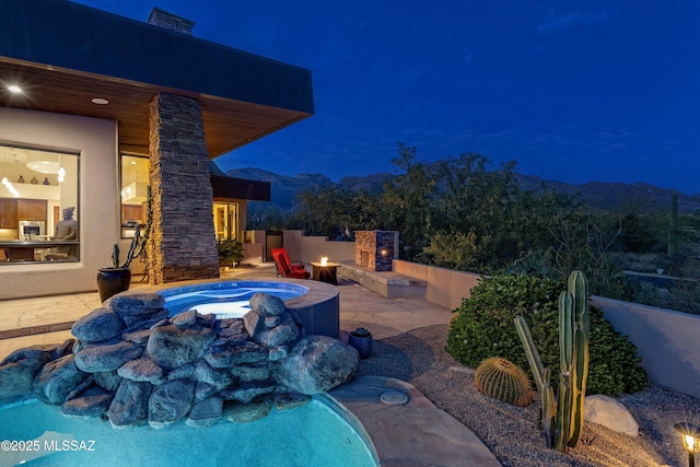 pool at twilight with a patio area and an outdoor fire pit