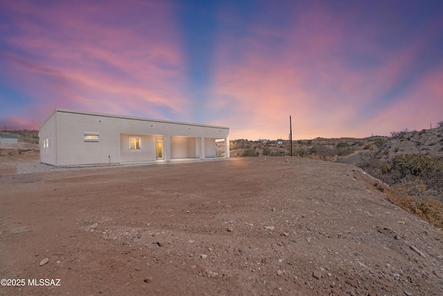 back of property featuring stucco siding