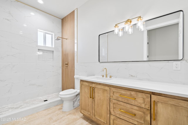 full bath featuring toilet, a tile shower, vanity, and tasteful backsplash