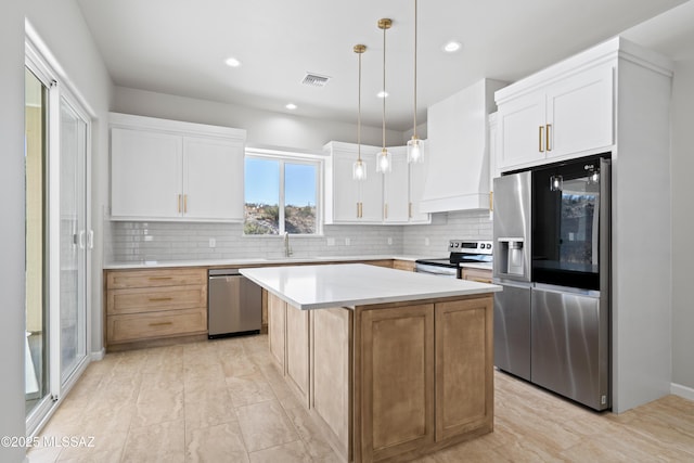 kitchen with appliances with stainless steel finishes, visible vents, light countertops, and backsplash
