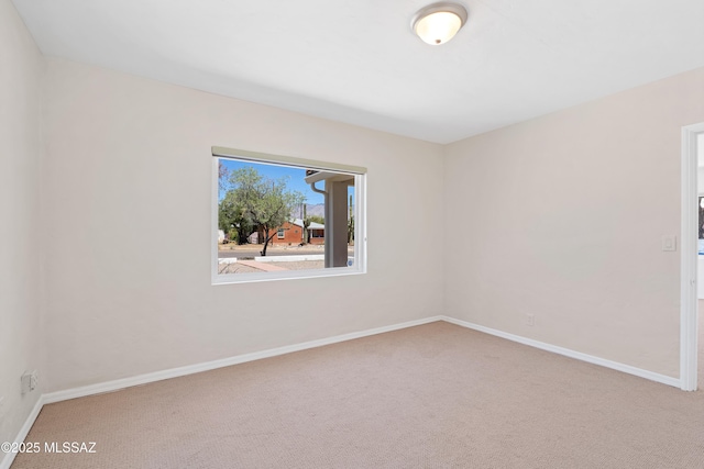 empty room featuring baseboards and carpet flooring