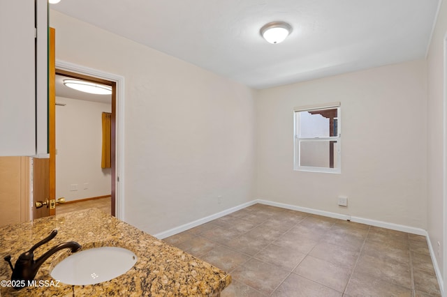 bathroom featuring baseboards and a sink