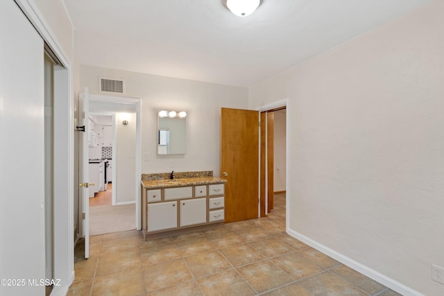 interior space featuring visible vents, a sink, and baseboards