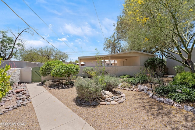 view of side of property featuring a gate, fence private yard, and brick siding