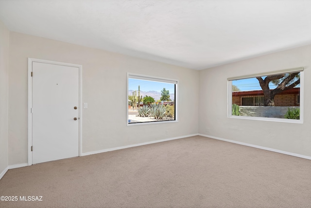 carpeted spare room featuring baseboards