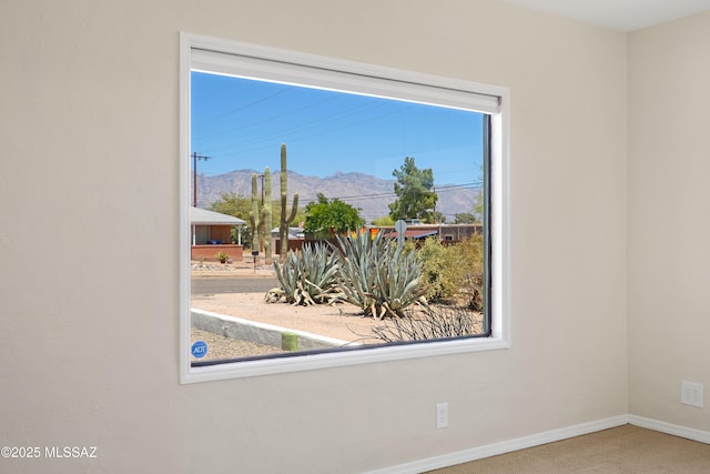 interior space featuring baseboards and a mountain view