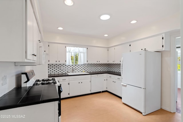 kitchen featuring a sink, decorative backsplash, white appliances, and white cabinetry