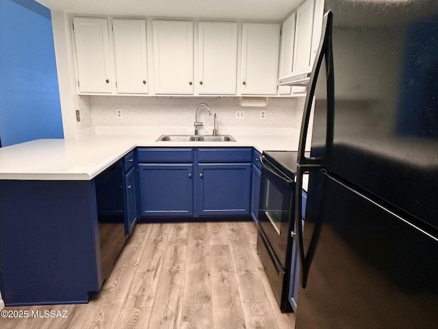 kitchen featuring a sink, black appliances, blue cabinetry, and white cabinetry