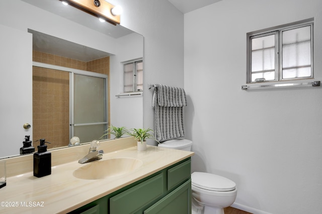 bathroom featuring vanity, toilet, and a stall shower