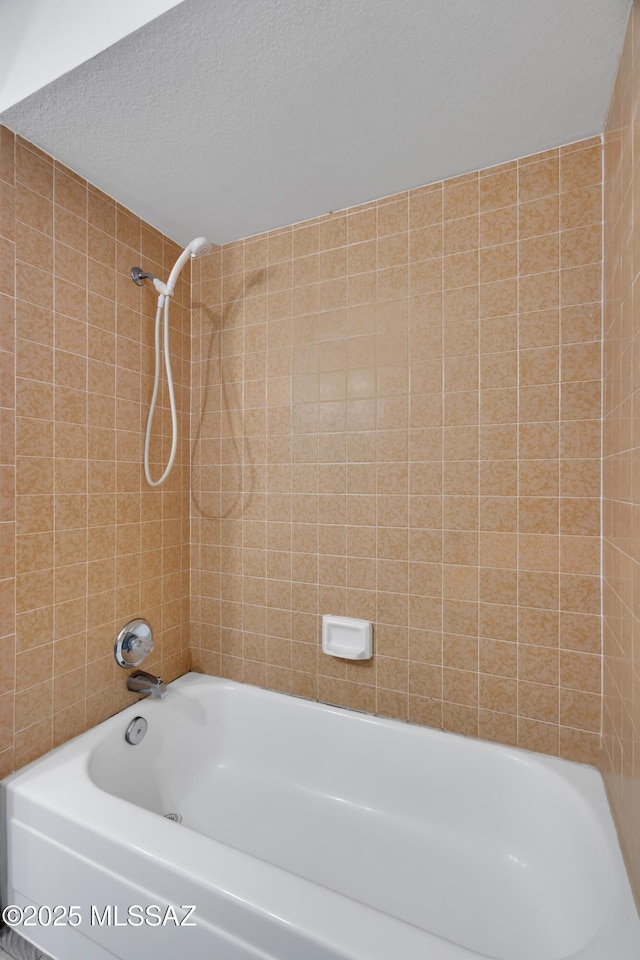 bathroom featuring bathing tub / shower combination and a textured ceiling
