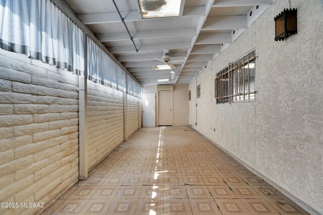 hallway with a wall unit AC and beam ceiling
