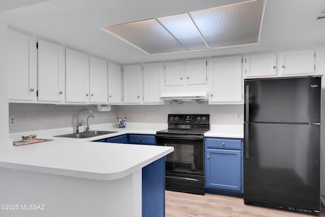kitchen with blue cabinets, a sink, white cabinets, black appliances, and under cabinet range hood