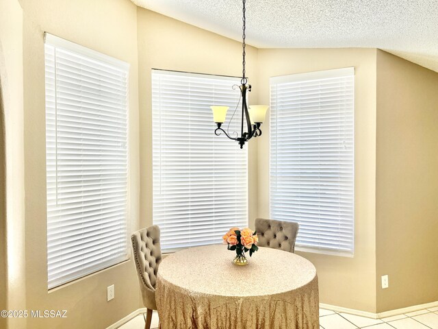 dining room featuring a chandelier, a textured ceiling, tile patterned floors, and baseboards
