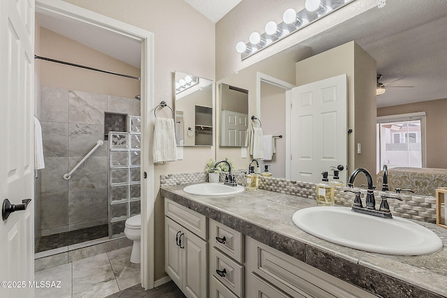 bathroom featuring a sink, a walk in shower, ceiling fan, and toilet