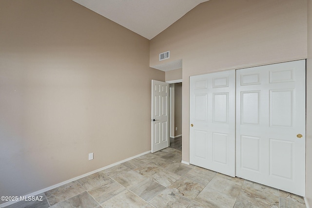 unfurnished bedroom featuring visible vents, baseboards, high vaulted ceiling, and a closet