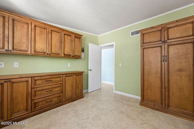 kitchen featuring crown molding, baseboards, brown cabinets, and visible vents