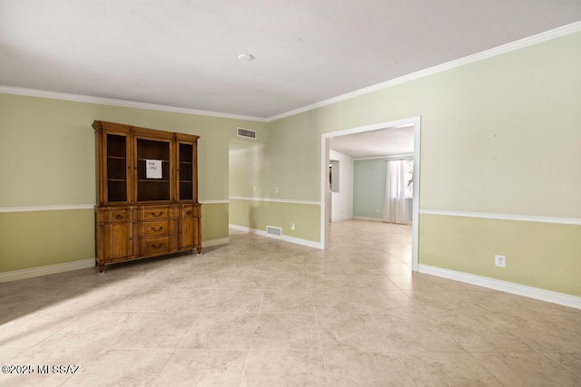 spare room with crown molding, baseboards, visible vents, and light tile patterned floors