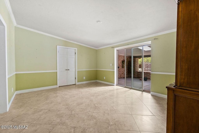 unfurnished room featuring baseboards, ornamental molding, and light tile patterned floors