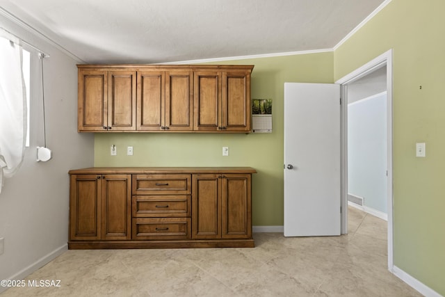 kitchen with crown molding, baseboards, and brown cabinets
