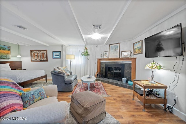 living area featuring baseboards, visible vents, and wood finished floors
