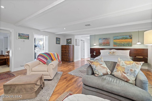 living room with visible vents, wood finished floors, and beamed ceiling