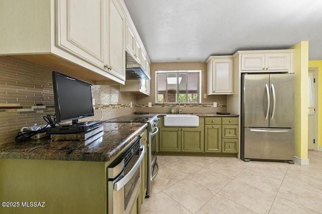 kitchen with appliances with stainless steel finishes, a wealth of natural light, a sink, and tasteful backsplash