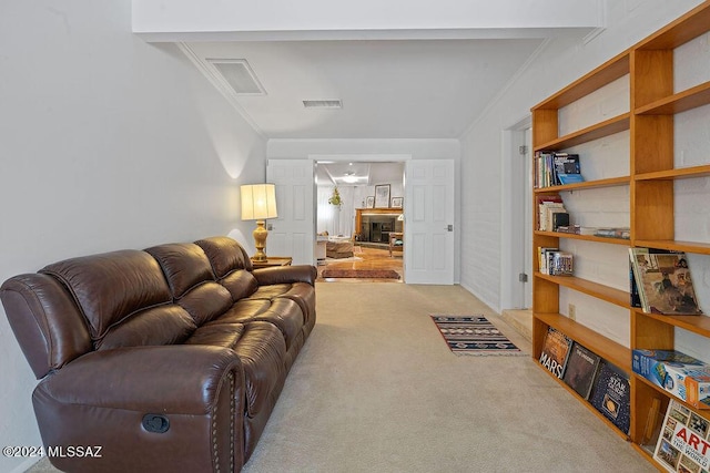 carpeted living room featuring crown molding and visible vents