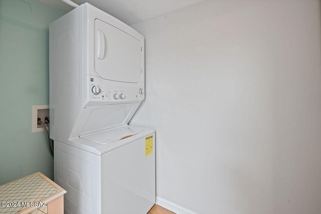 laundry room featuring stacked washer / drying machine and laundry area