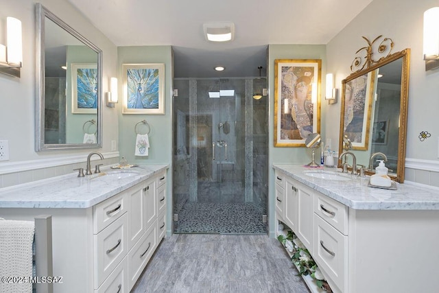 bathroom with a sink, a stall shower, and two vanities