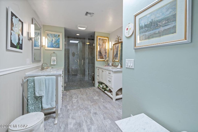 bathroom featuring two vanities, visible vents, a shower stall, and a sink