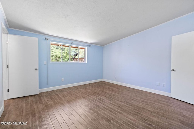 unfurnished room featuring baseboards and wood finished floors