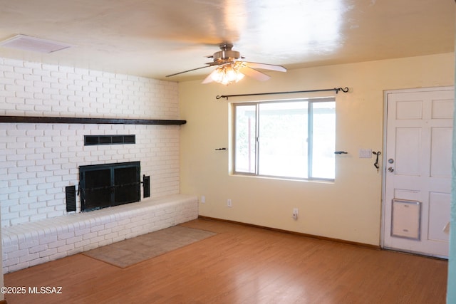 1350 E Goosetree Ln, Safford, AZ 85546 - unfurnished living room featuring visible vents, a brick fireplace, wood finished floors, baseboards, and ceiling fan