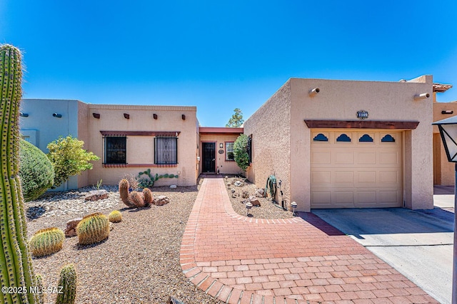 southwest-style home with an attached garage, stucco siding, and driveway