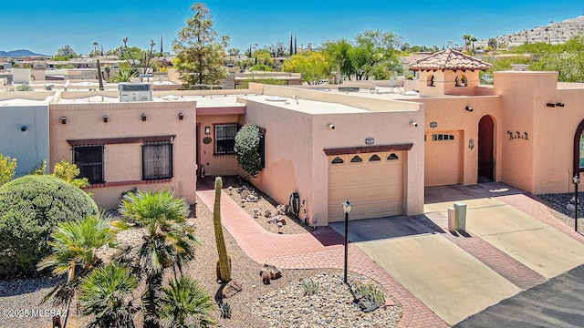 adobe home with stucco siding and driveway