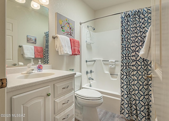 bathroom featuring toilet, wood finished floors, shower / bath combo, and vanity