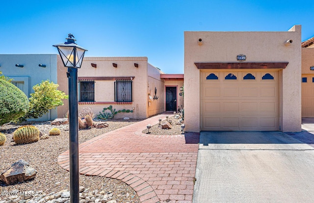 pueblo revival-style home featuring stucco siding and driveway