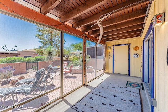 unfurnished sunroom featuring beamed ceiling