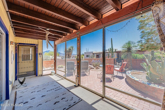unfurnished sunroom with beamed ceiling