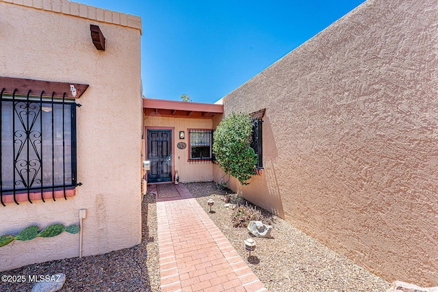 entrance to property featuring stucco siding