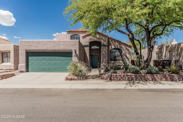 view of front of home with a garage, stucco siding, fence, and concrete driveway
