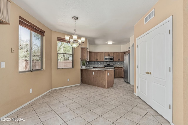 kitchen featuring a sink, a chandelier, stainless steel appliances, a peninsula, and visible vents
