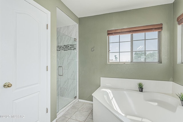 full bathroom with tile patterned flooring, a shower stall, a textured wall, and a garden tub