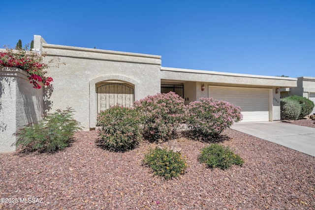 view of front facade featuring a garage, driveway, and stucco siding