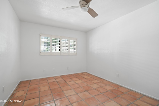 spare room featuring baseboards and a ceiling fan