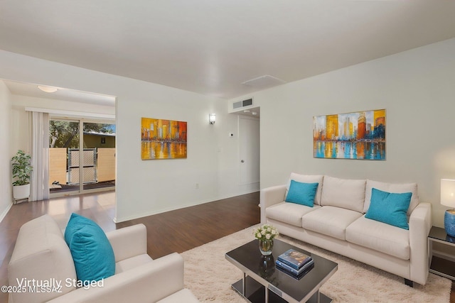 living room featuring baseboards, visible vents, and wood finished floors