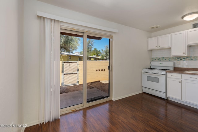 kitchen featuring white cabinets, dark wood-type flooring, white range with gas stovetop, and backsplash
