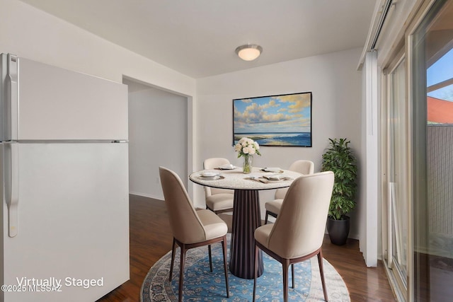 dining space with dark wood-style flooring and baseboards