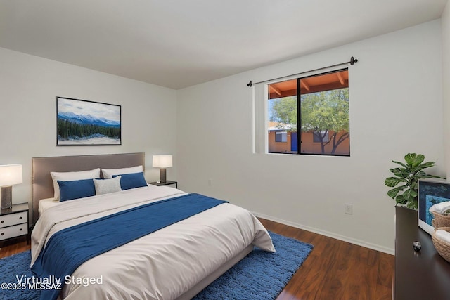 bedroom featuring baseboards and wood finished floors