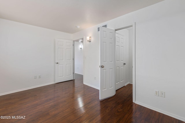 unfurnished bedroom featuring wood finished floors, visible vents, and baseboards