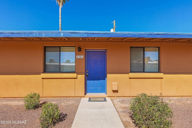 property entrance featuring stucco siding